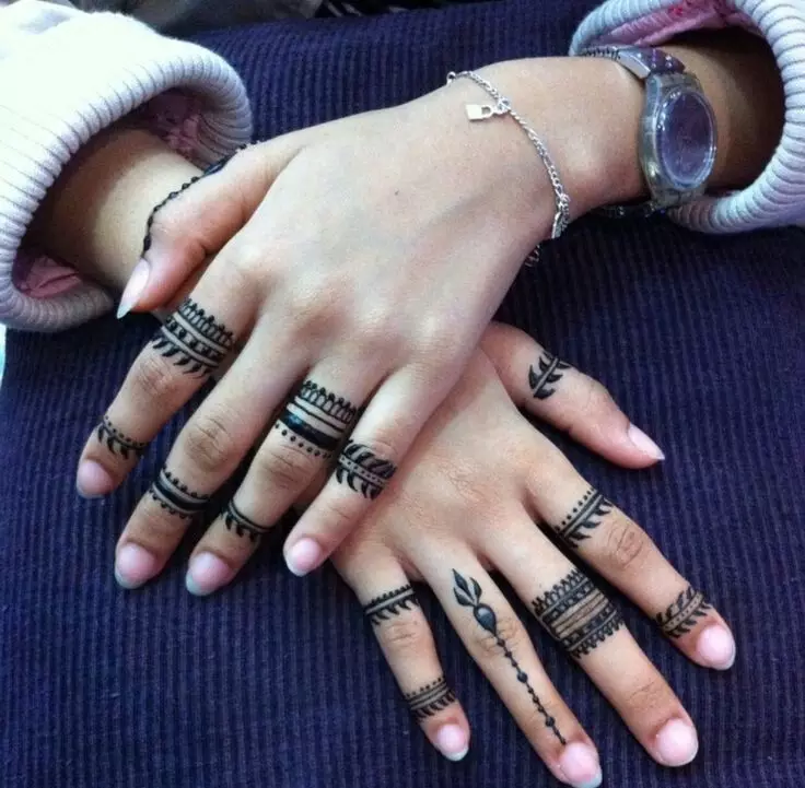 Tatuering på fingrarna för tjejer (68 bilder): kvinnliga små tatueringar och deras skisser. Mini-tatuering på sidan av det namnlösa fingret och på den stora, på Maizin-källan och på de andra fingrarna 247_23