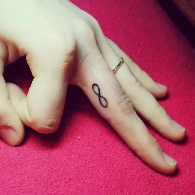 Tetovaža na prstima za djevojčice (68 fotografija): ženske male tetovaže i njihove skice. Mini-tetovaže sa strane bezimenog prsta i na velikom, na mograma maizina i na drugim prstima 247_24