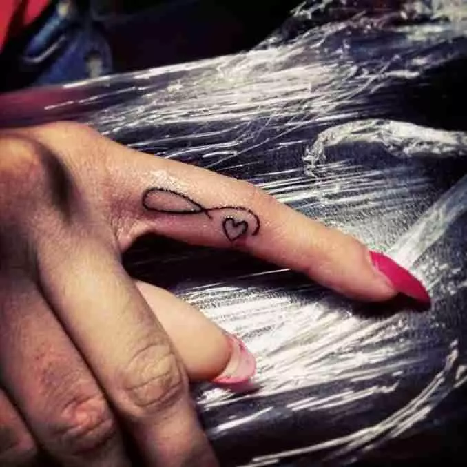Tatuering på fingrarna för tjejer (68 bilder): kvinnliga små tatueringar och deras skisser. Mini-tatuering på sidan av det namnlösa fingret och på den stora, på Maizin-källan och på de andra fingrarna 247_27