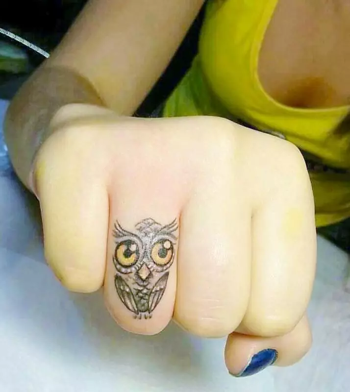 Tattoo op de vingers voor meisjes (68 foto's): vrouwelijke kleine tatoeages en hun schetsen. Mini-tattoo aan de zijkant van de naamloze vinger en op de grote, op de Maizin-kerel en op de andere vingers 247_33