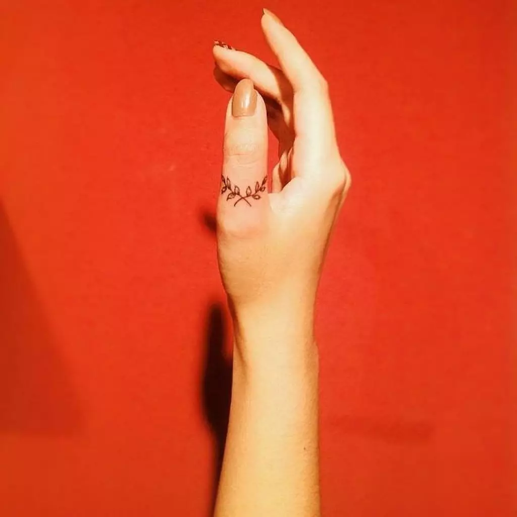 Tetovaža na prstima za djevojčice (68 fotografija): ženske male tetovaže i njihove skice. Mini-tetovaže sa strane bezimenog prsta i na velikom, na mograma maizina i na drugim prstima 247_57