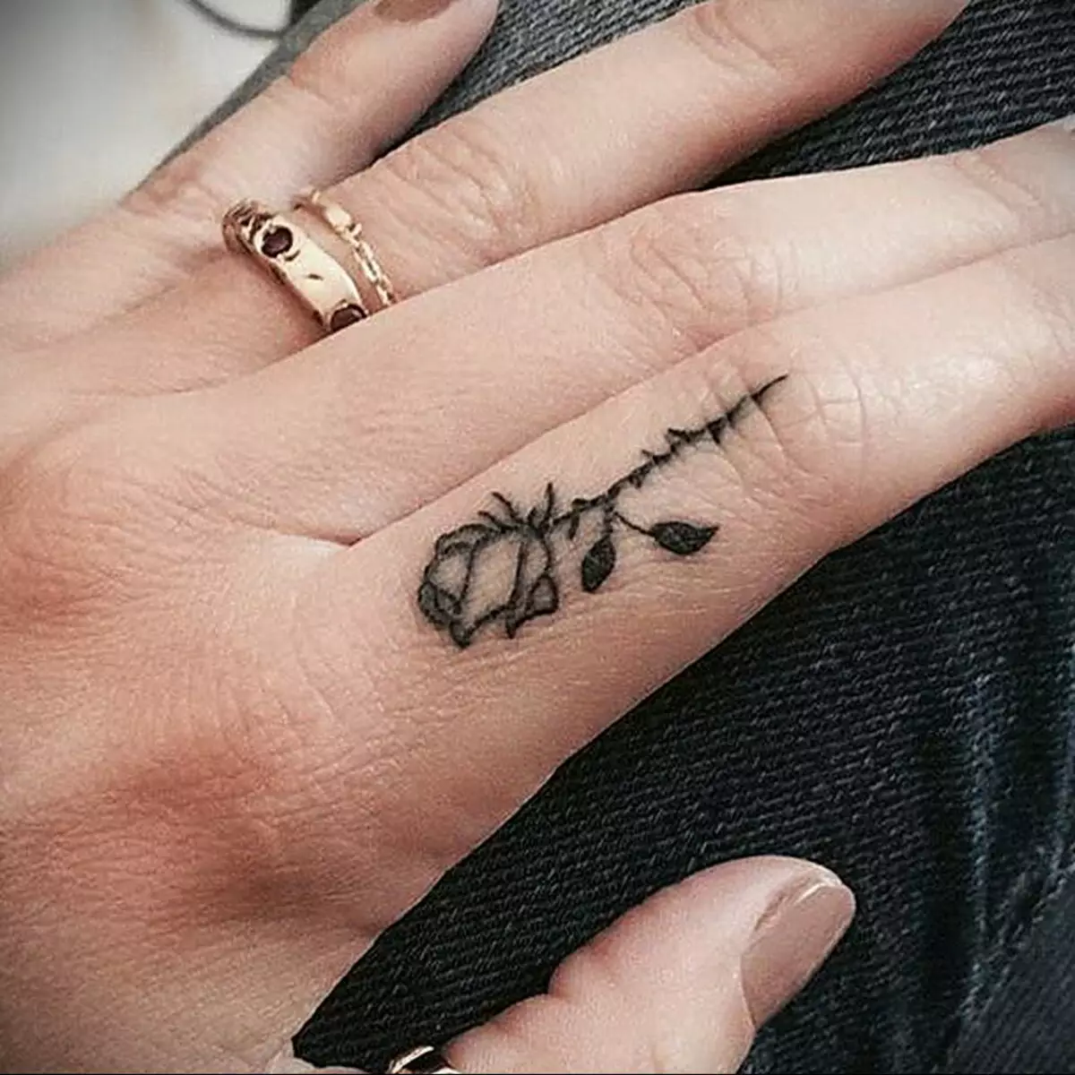 Tattoo op de vingers voor meisjes (68 foto's): vrouwelijke kleine tatoeages en hun schetsen. Mini-tattoo aan de zijkant van de naamloze vinger en op de grote, op de Maizin-kerel en op de andere vingers 247_7