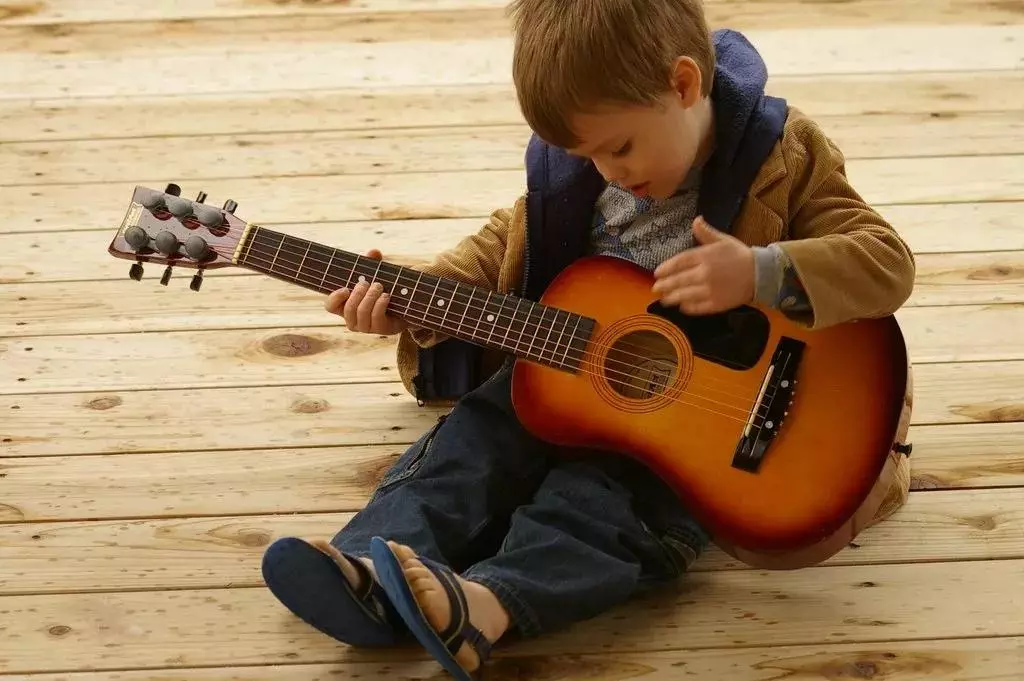 بچوں کے گٹار (49 فوٹو): 6-7 سال کی عمر کے بچوں کے لئے ایک حقیقی گٹار کا انتخاب کیسے کریں اور نوجوانوں کے ابتدائی سال 10 سال؟ تار اور دیگر ماڈل کے ساتھ دونک گٹار 25439_3