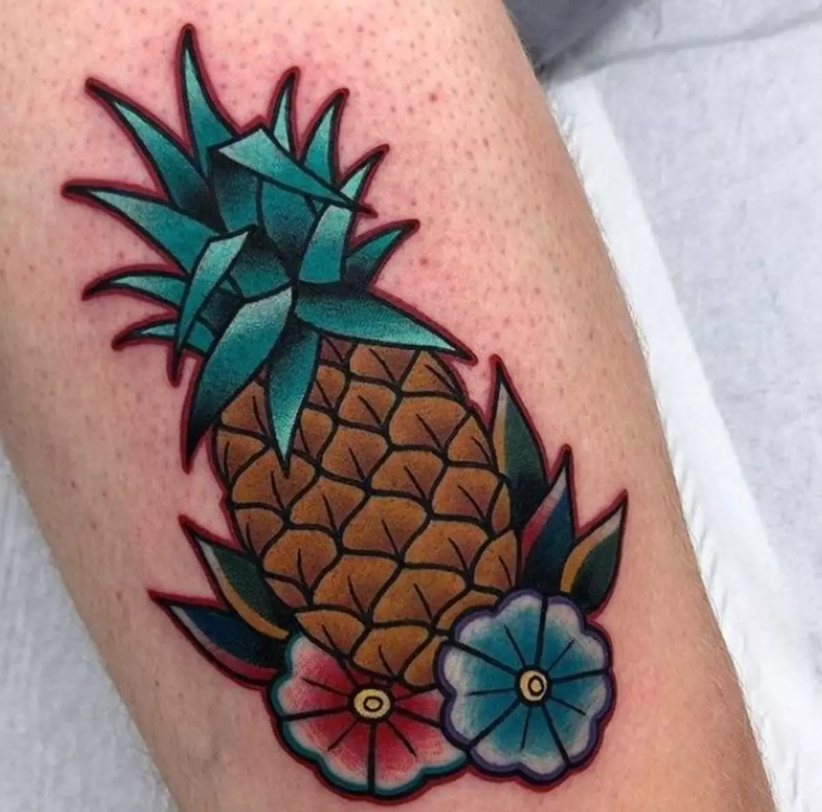 Tattoo "ananas": sketsen fan tatoeaazjes en betsjutting, lytse en grutte tatoet op 'e skonk, hân en oare dielen fan it lichem