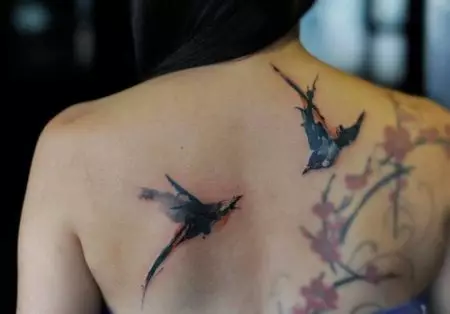 Tattoo me swallows (45 foto): kuptim dhe skica, tatuazhe në qafën e vajzave dhe në klavikul, në dorë në dore dhe shpatull, këmbë dhe në pjesë të tjera të trupit 278_23