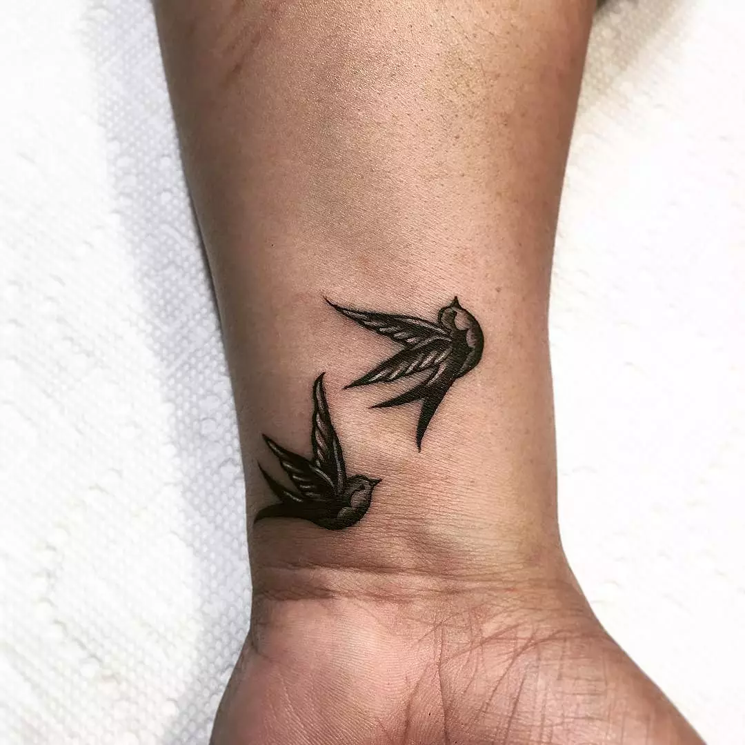 Tattoo me swallows (45 foto): kuptim dhe skica, tatuazhe në qafën e vajzave dhe në klavikul, në dorë në dore dhe shpatull, këmbë dhe në pjesë të tjera të trupit 278_8