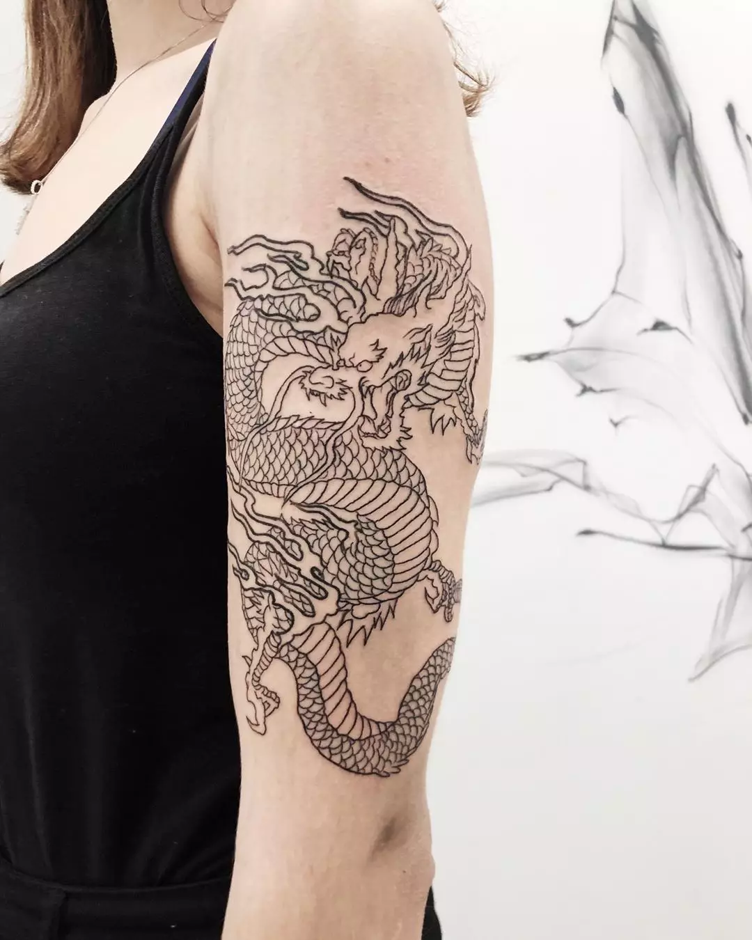 Татуировка с дракони (68 снимки): скици и ценности. Татуировки на ръка и на рамото, на гърба и на бедрото, по шията и крака, на предмишницата и върху други части на тялото 279_25