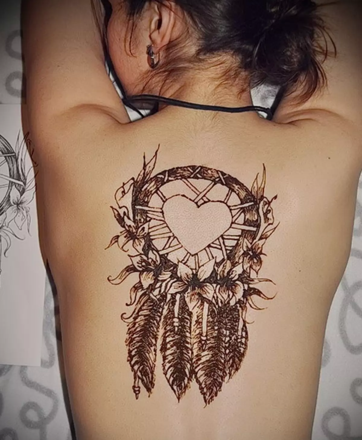 Mehendi på baksidan (32 foton): Kvinnors teckningar av henna och män, tatuering på toppen av baksidan och nedre delen, ljus skisser mehendi i form av vingar och andra alternativ 293_19