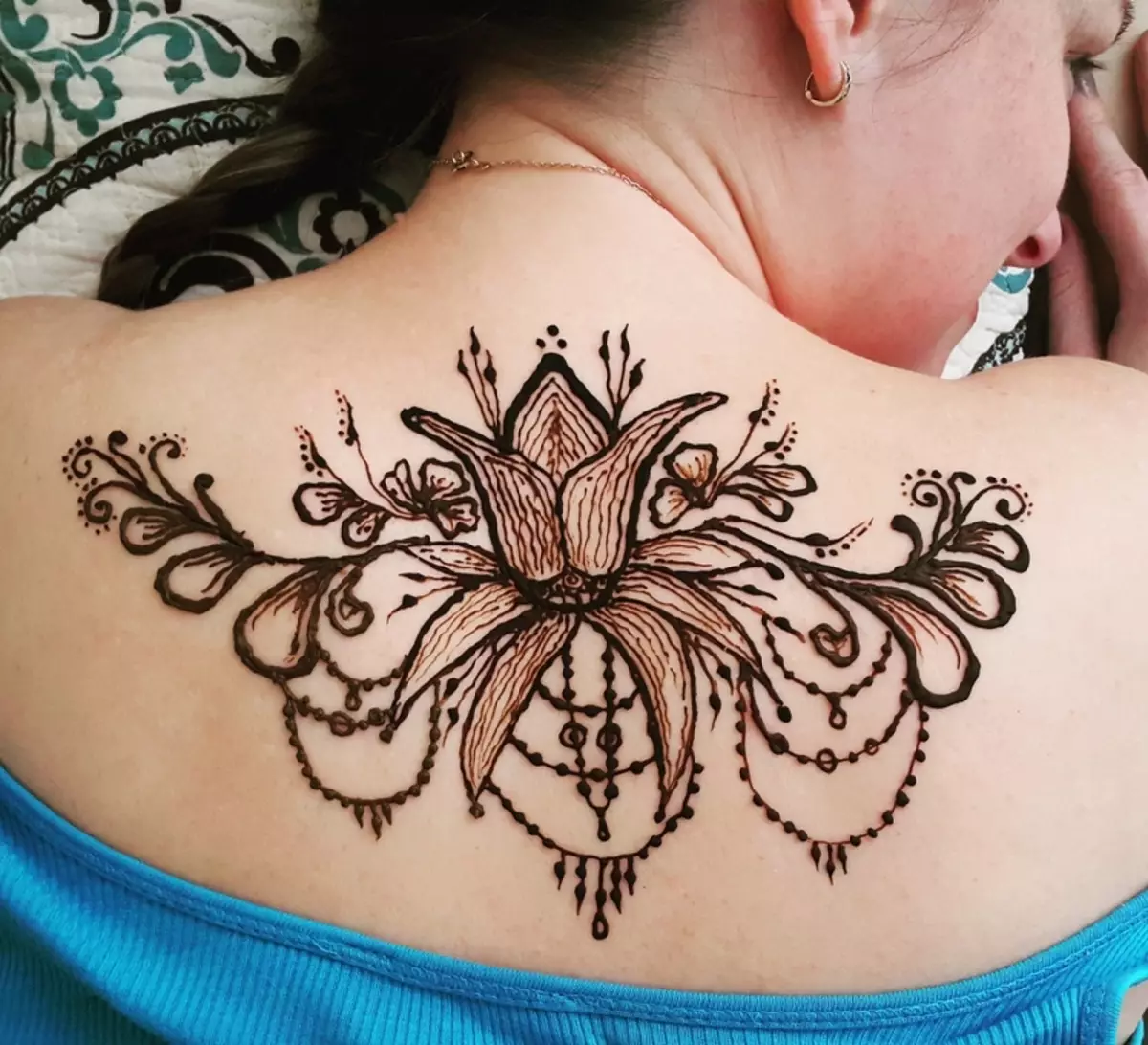 Mehendi sul retro (32 foto): Disegni femminili di hennè e uomini, tatuaggio sulla parte superiore della schiena e nella parte bassa della schiena, schizzi leggeri Mehendi sotto forma di ali e altre opzioni 293_29