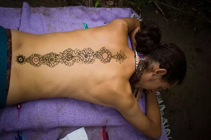 Mehendi sul retro (32 foto): Disegni femminili di hennè e uomini, tatuaggio sulla parte superiore della schiena e nella parte bassa della schiena, schizzi leggeri Mehendi sotto forma di ali e altre opzioni 293_6