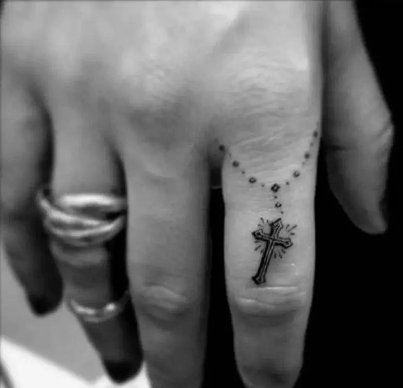Tattooの指の上の「十字」：入れ墨の価値。中指とMizinzaの交差点、インジケーター上および名前なしの指