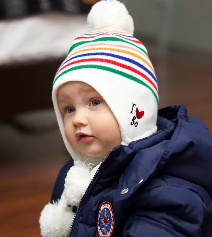 Бебешки шапки с помпони (65 снимки): с кожа естествено, с две помпони, с едно голямо, бяло и черна шапка-каска 2998_15