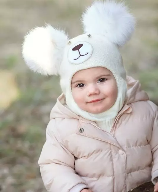 Бебешки шапки с помпони (65 снимки): с кожа естествено, с две помпони, с едно голямо, бяло и черна шапка-каска 2998_20