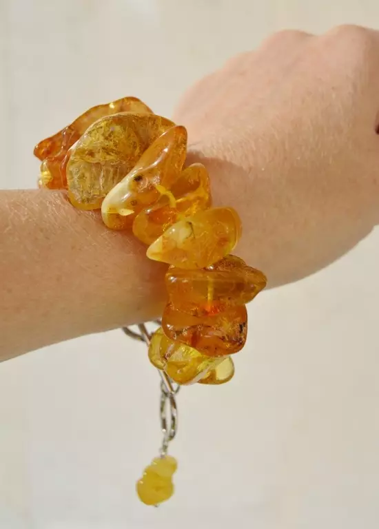 Amber eskumuturrekoa (51 argazki): Amber eskumuturreko propietateak, zer eskuz jantzita 3082_50