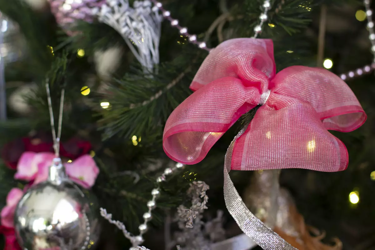 Kalėdų eglutės apdaila su lankais (35 nuotraukos): lankai su kamuoliais ir gėlėmis, su juostelėmis ir karoliukais, gražiai papuošė Kalėdų eglutę su raudonomis ir baltomis lankais 7640_20
