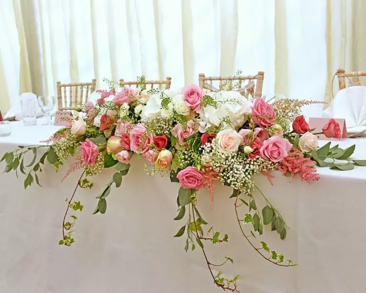 शादी की मेज पर फूल व्यवस्था (28 तस्वीरें): अपने हाथों से जीवित और कृत्रिम फूलों के साथ एक शादी की मेज की सजावट 7974_16