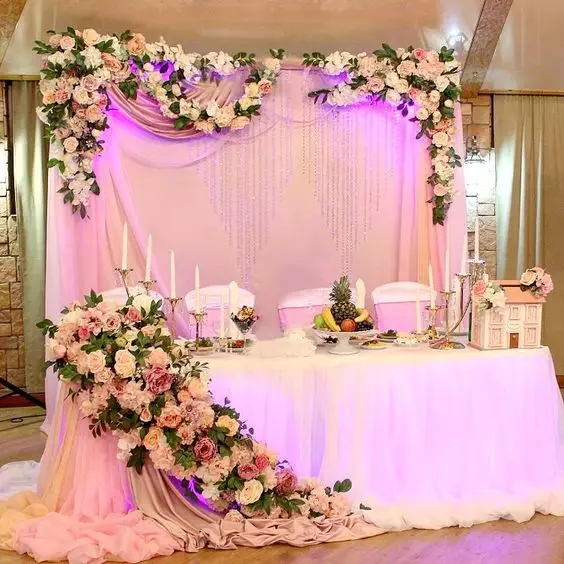 शादी की मेज पर फूल व्यवस्था (28 तस्वीरें): अपने हाथों से जीवित और कृत्रिम फूलों के साथ एक शादी की मेज की सजावट 7974_7