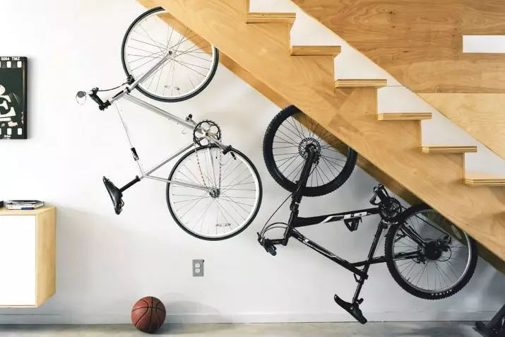 Bagaimana untuk menyimpan basikal di apartmen? Idea untuk menyimpan rumah basikal di dinding dan di siling, jika tidak ada tempat sama sekali? Kaedah dan sistem penyimpanan di apartmen 8545_12