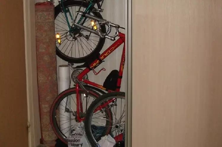 Bagaimana untuk menyimpan basikal di apartmen? Idea untuk menyimpan rumah basikal di dinding dan di siling, jika tidak ada tempat sama sekali? Kaedah dan sistem penyimpanan di apartmen 8545_24