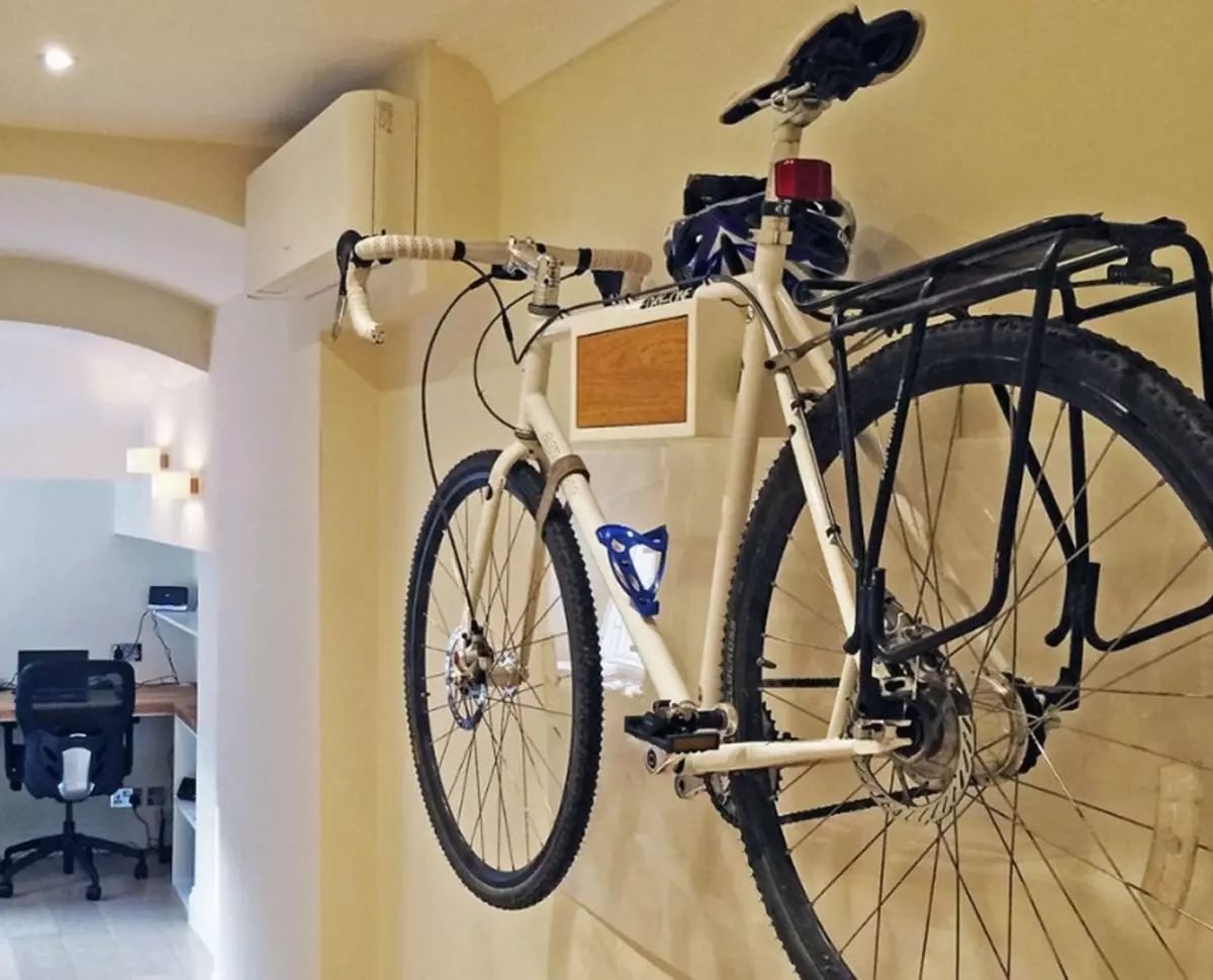 Bagaimana untuk menyimpan basikal di apartmen? Idea untuk menyimpan rumah basikal di dinding dan di siling, jika tidak ada tempat sama sekali? Kaedah dan sistem penyimpanan di apartmen 8545_7