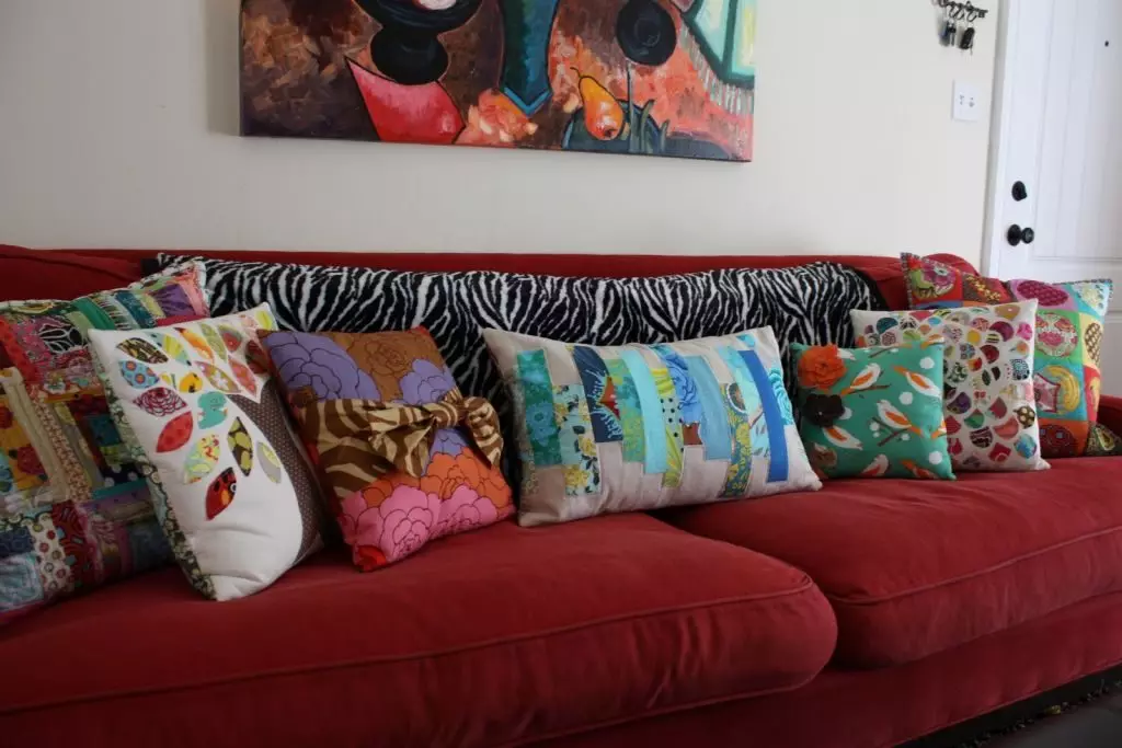 Pagalvės sofa (56 nuotraukos): dekoratyvinės didelės ir mažos minkštos pagalvės ant gilios sofos, standartinių dydžių, stačiakampio ir apvalios 9016_44
