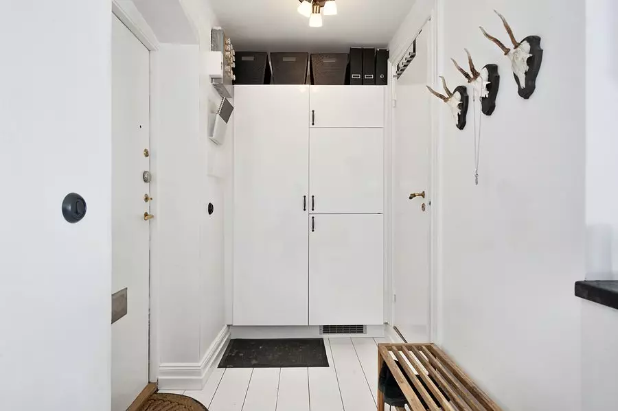 Белата влезна сала (76 фотографии): избор на мебел во коридорот во бело. Дизајн на ходникот во црно-бели и други комбинации во станот 9264_10