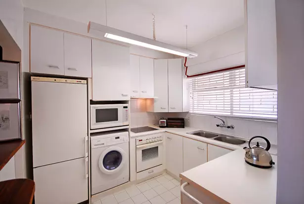 洗濯機付きのキッチン（45枚の写真）：テーブルトップとコーナーキッチンヘッドセットの下の機械。冷蔵庫と小さなキッチンの内部に車を隠す方法は？ 9419_16