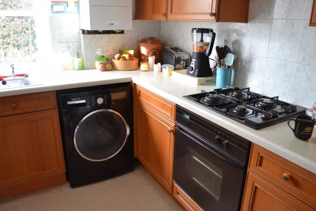 洗濯機付きのキッチン（45枚の写真）：テーブルトップとコーナーキッチンヘッドセットの下の機械。冷蔵庫と小さなキッチンの内部に車を隠す方法は？ 9419_26