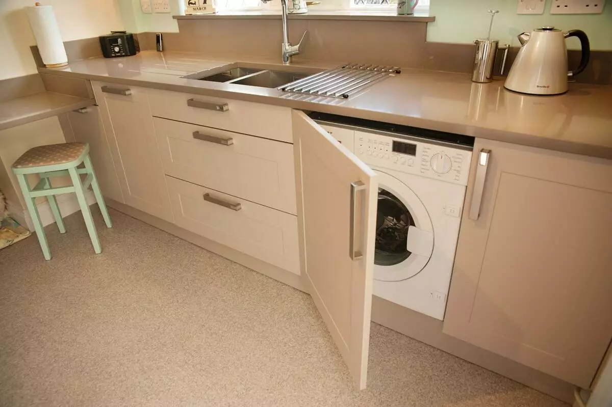 Dapur dengan mesin basuh (45 foto): Mesin di bawah meja atas dan di alat dengar dapur sudut. Bagaimana untuk menyembunyikan kereta di bahagian dalam dapur kecil dengan peti sejuk? 9419_29