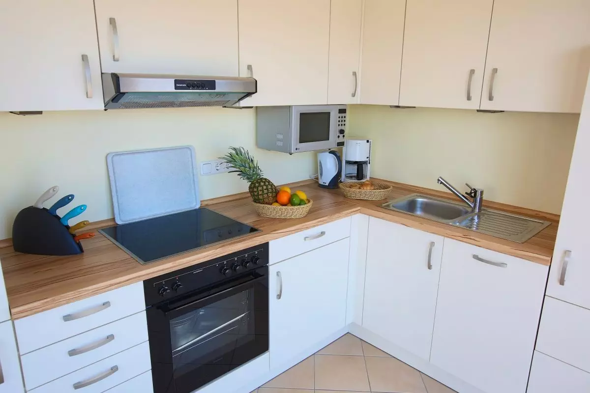 Valg for plassering av mikrobølger på kjøkkenet (40 bilder): Hvor skal du sette den på et lite kjøkken? Ideer for plasseringen av mikrobølgeovnen i kjøkkenhodetelefonen 9421_4