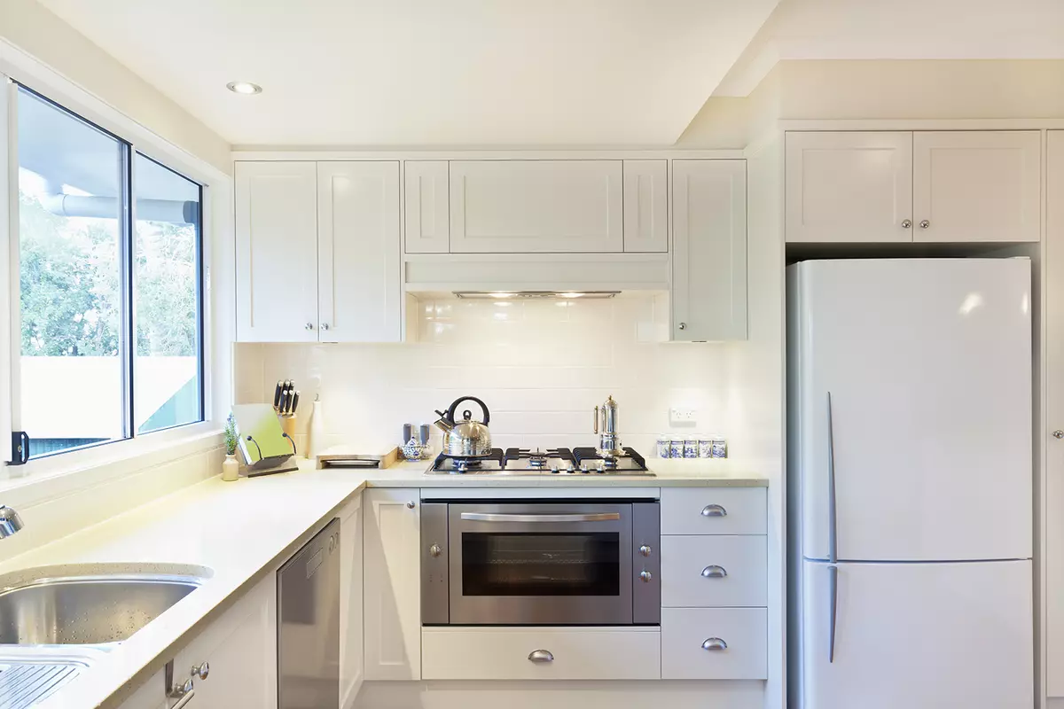 Design av lite kjøkken med kjøleskap (76 bilder): Hvor skal du sette et kjøleskap? Hjørne og innebygde kjøkkenhodetelefoner med kjøleskap i interiøret. Hvordan plasserer du det i rommet med et vindu? 9504_56
