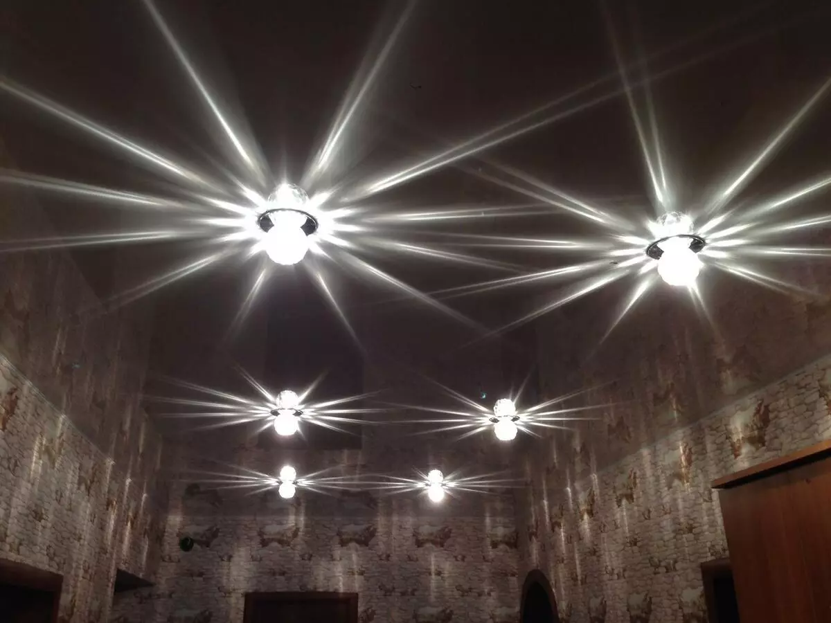 Het aansteken van de spanplafond in de hal (61 foto's): Hoe lampen te vinden voor het benadrukken in de woonkamer zonder een kroonluchter? Kenmerken van punt verlichting, opties voor de locatie van de LED-lampen 9617_13