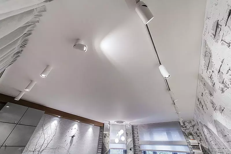 โคมไฟเพดานยืดในห้องโถง (61 ภาพ): วิธีการหาโคมไฟสำหรับไฮไลต์ในห้องนั่งเล่นโดยไม่ต้องโคมระย้าหรือไม่? คุณสมบัติของแสงจุดสำหรับตัวเลือกสถานที่ตั้งของหลอดไฟ LED 9617_24
