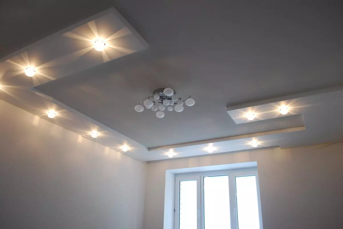 Het aansteken van de spanplafond in de hal (61 foto's): Hoe lampen te vinden voor het benadrukken in de woonkamer zonder een kroonluchter? Kenmerken van punt verlichting, opties voor de locatie van de LED-lampen 9617_26
