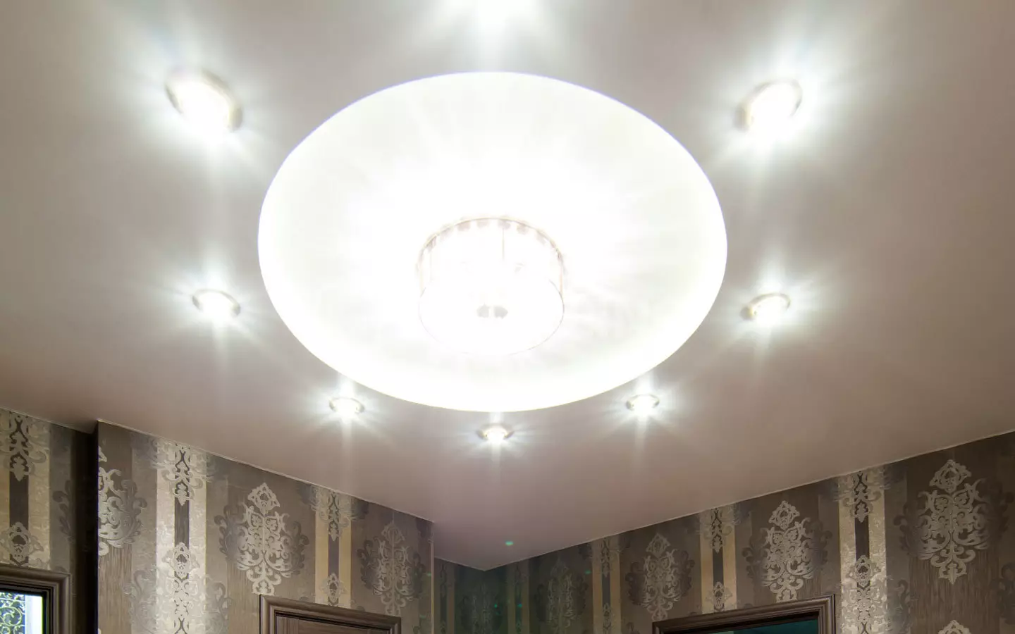 Het aansteken van de spanplafond in de hal (61 foto's): Hoe lampen te vinden voor het benadrukken in de woonkamer zonder een kroonluchter? Kenmerken van punt verlichting, opties voor de locatie van de LED-lampen 9617_34